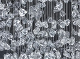 Crystal-like shapes hanging vertically against a black background