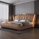 Modern bedroom with a brown upholstered bed in a well-lit room.