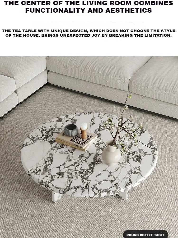 Round marble coffee table in a living room setting with decorative items.