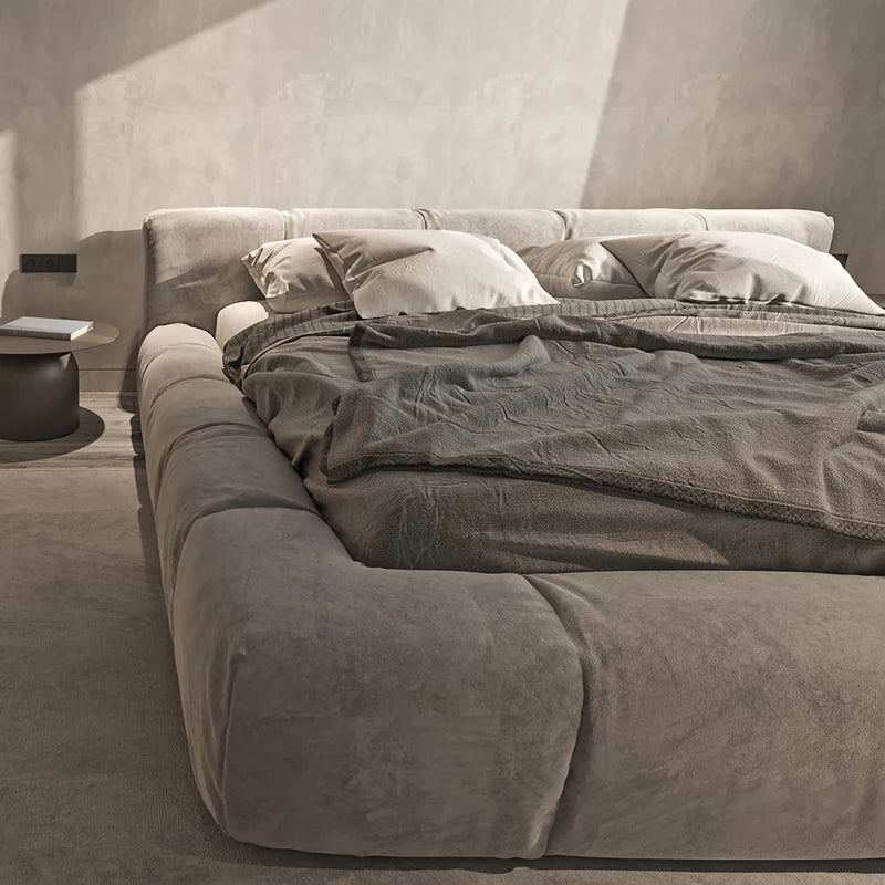 Italian upholstered bed frame with plush fabric and cozy bedding, showcasing modern elegance and comfort.