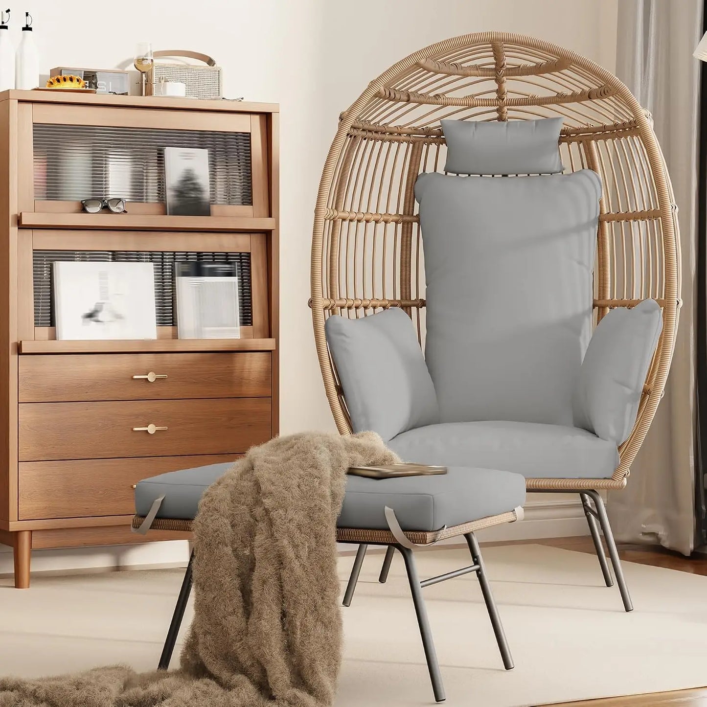 Waterproof egg-shaped wicker chair with gray cushions and matching ottoman in stylish indoor setting.