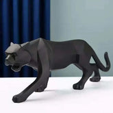 Black panther figurine on a white surface with a blue curtain background