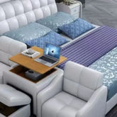 luxury smart leather king size bed with blue pillows, wooden side table, and laptop on the surface.