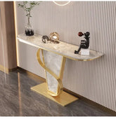 Decorative console table with marble top and gold base against a striped wall.
