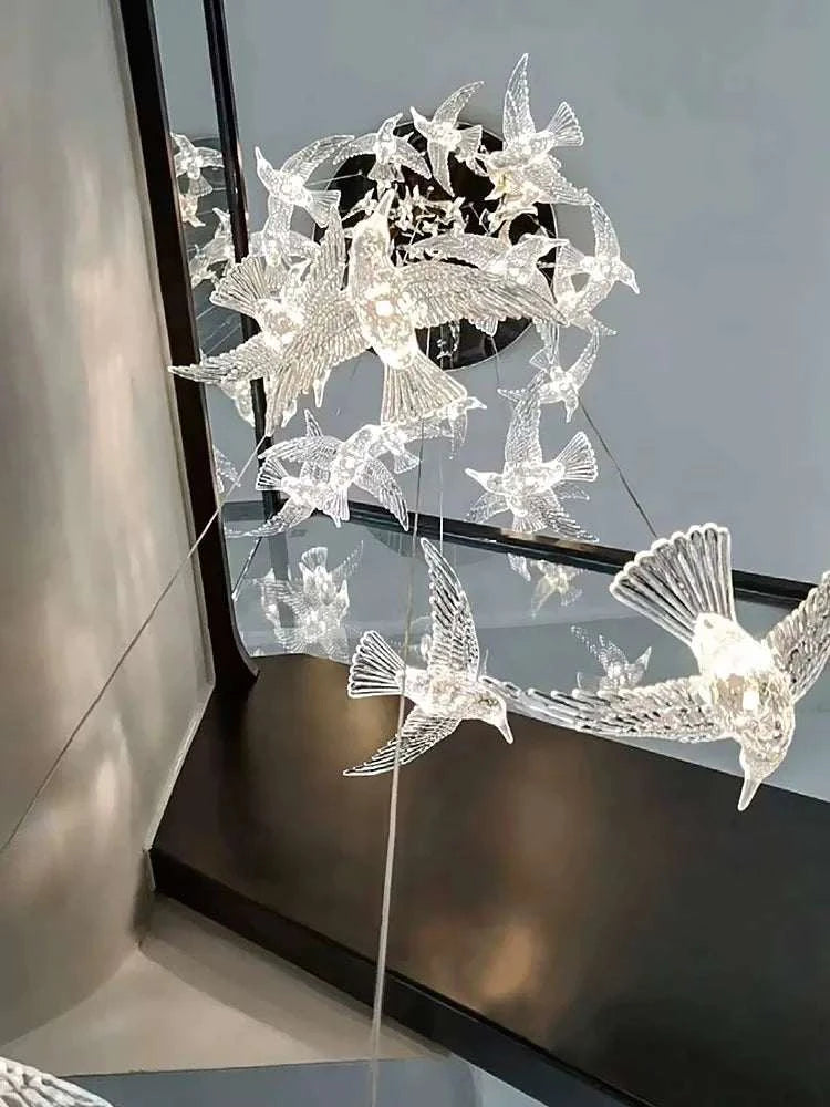 Decorative metal sculpture of birds on a stand in front of a mirror.