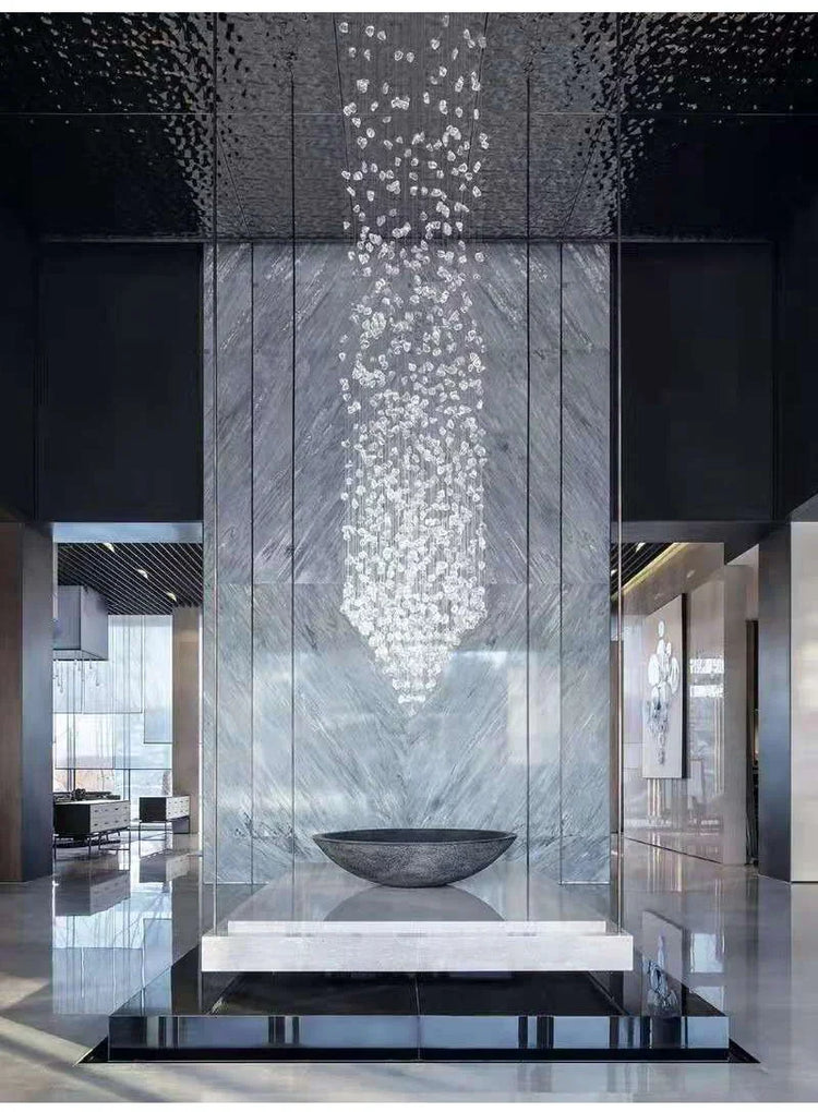 Modern indoor water feature with a glass wall and decorative bowl.