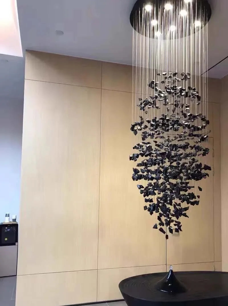 Modern chandelier with black butterfly decorations hanging from a ceiling