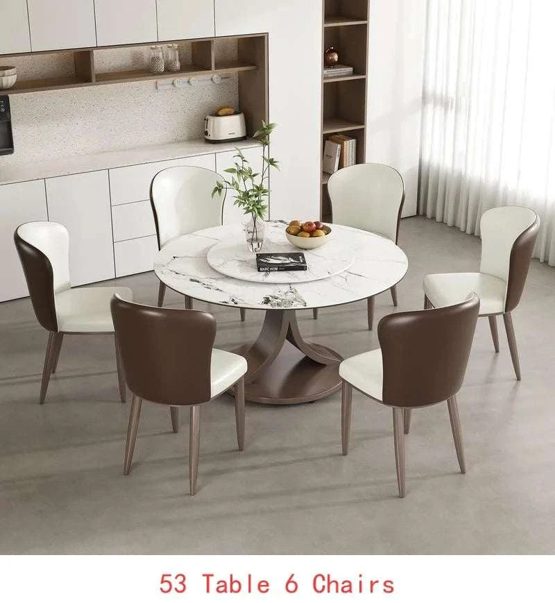 Dining area with a round marble table and six chairs in a modern kitchen setting.