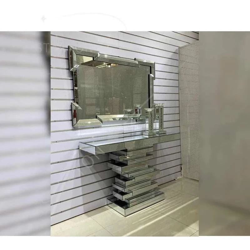 Modern glass console table with mirror against a white paneled wall.