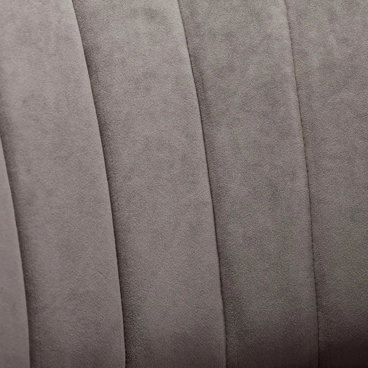 Close-up of the plush upholstery on modern swivel barrel chairs in soft gray fabric.