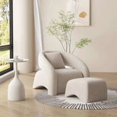 Modern beige armchair with matching ottoman in a bright living room.