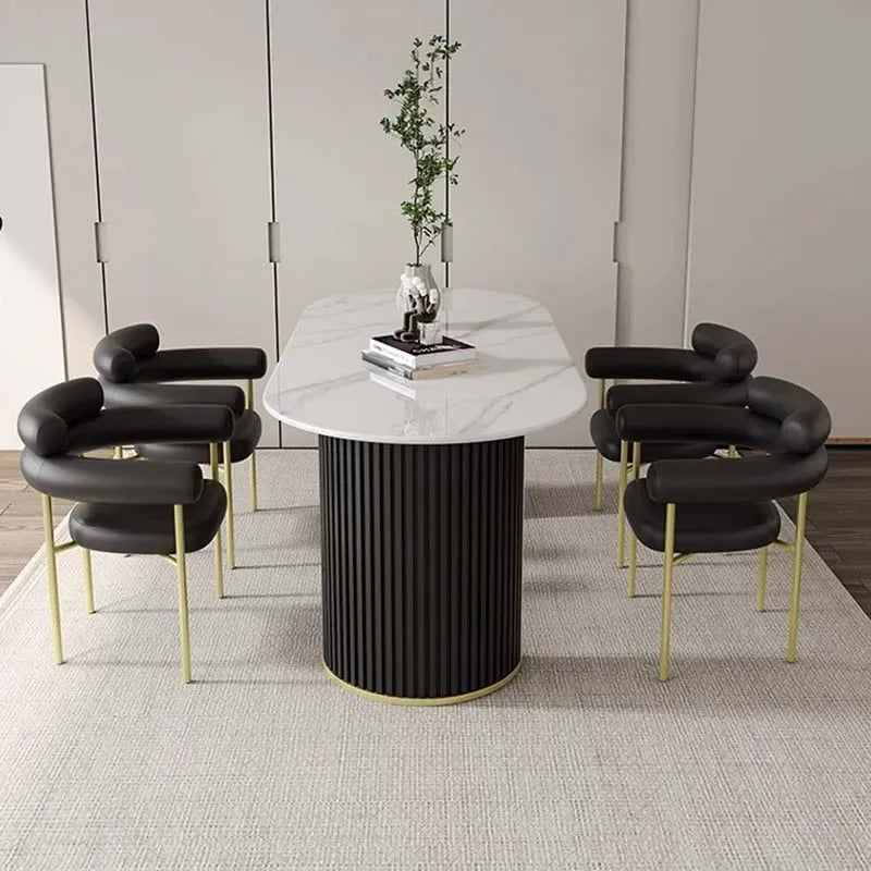 Modern dining set with a marble table and black chairs in a minimalistic room.