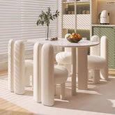 Modern dining set with a round table and white chairs in a bright room.