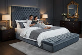 Couple relaxing on a modern upholstered king size bed with tufted velvet headboard in a contemporary bedroom.