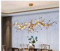 Gold chandelier hanging above a dining table with a vase of flowers on a neutral background
