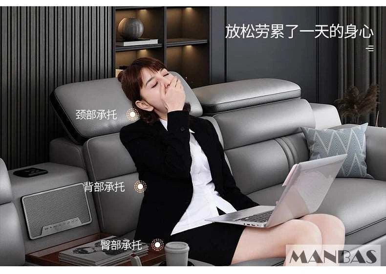 Woman using a laptop on a gray massage sofa with text and branding visible