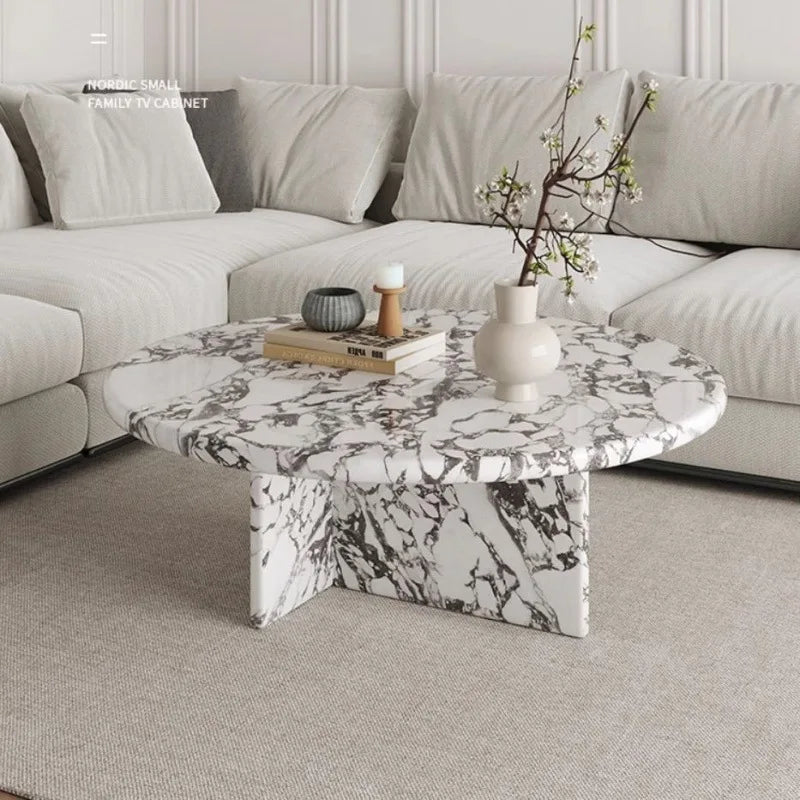 Marble coffee table in a living room setting with a sofa and decorative items.