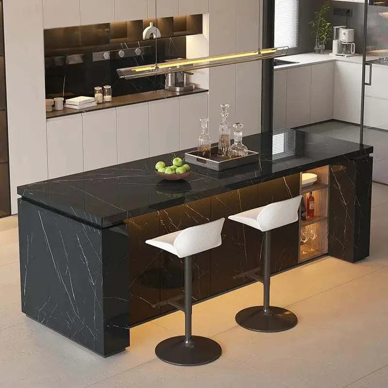Modern kitchen island with black marble countertop and white stools.