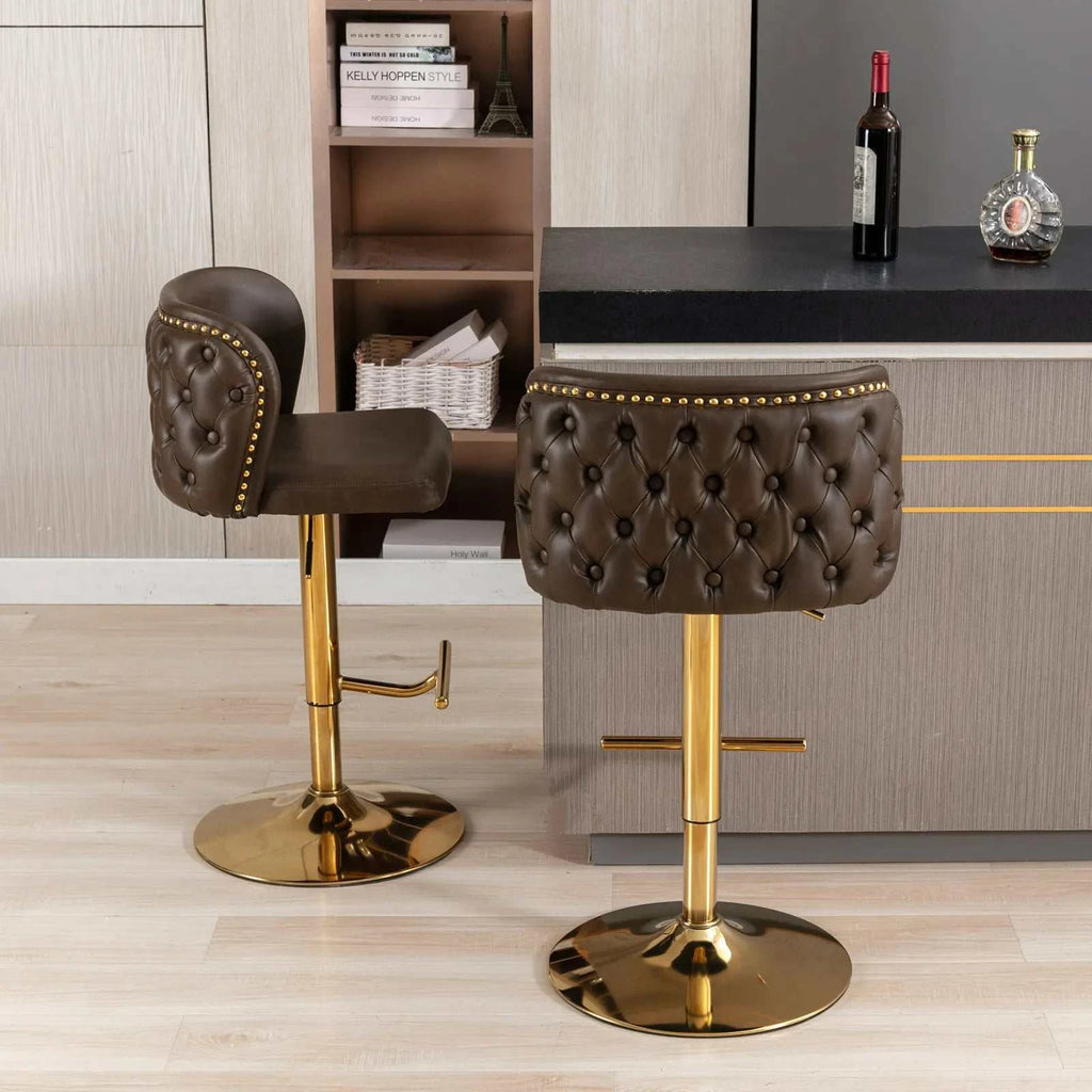 Two brown tufted bar stools with gold legs in a modern kitchen setting.