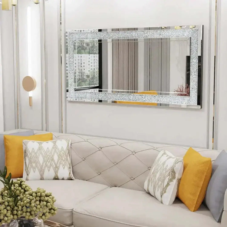 Large silver frameless mirror with sparkly crystal rhinestone and diamond border above sofa