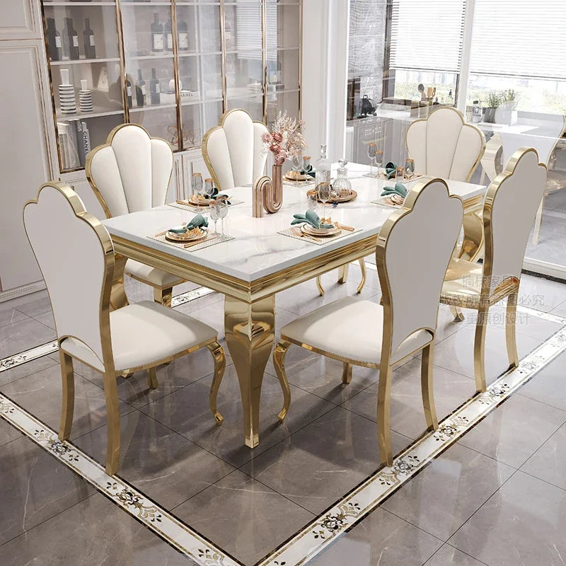 Dining table set with marble top and gold legs in a modern kitchen.