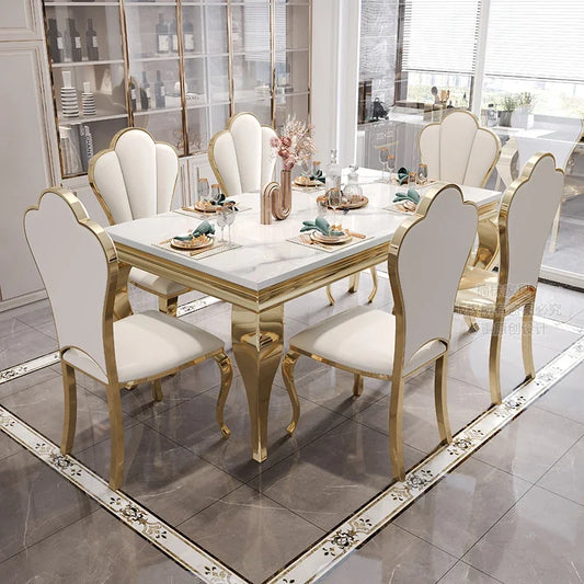 Dining table set with marble top and gold legs in a modern kitchen.