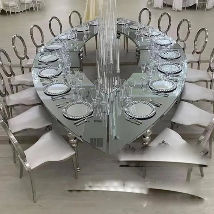 Large oval dining table with chairs and crystal chandelier in a formal setting.