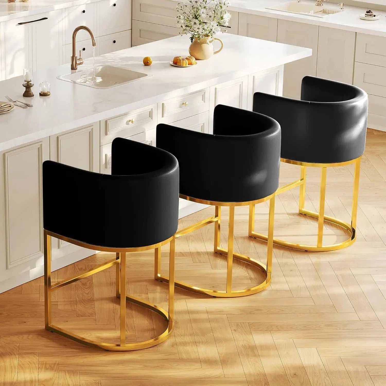 Set of 3 modern bar stools with black PU leather barrel seats and gold metal frames in a kitchen setting