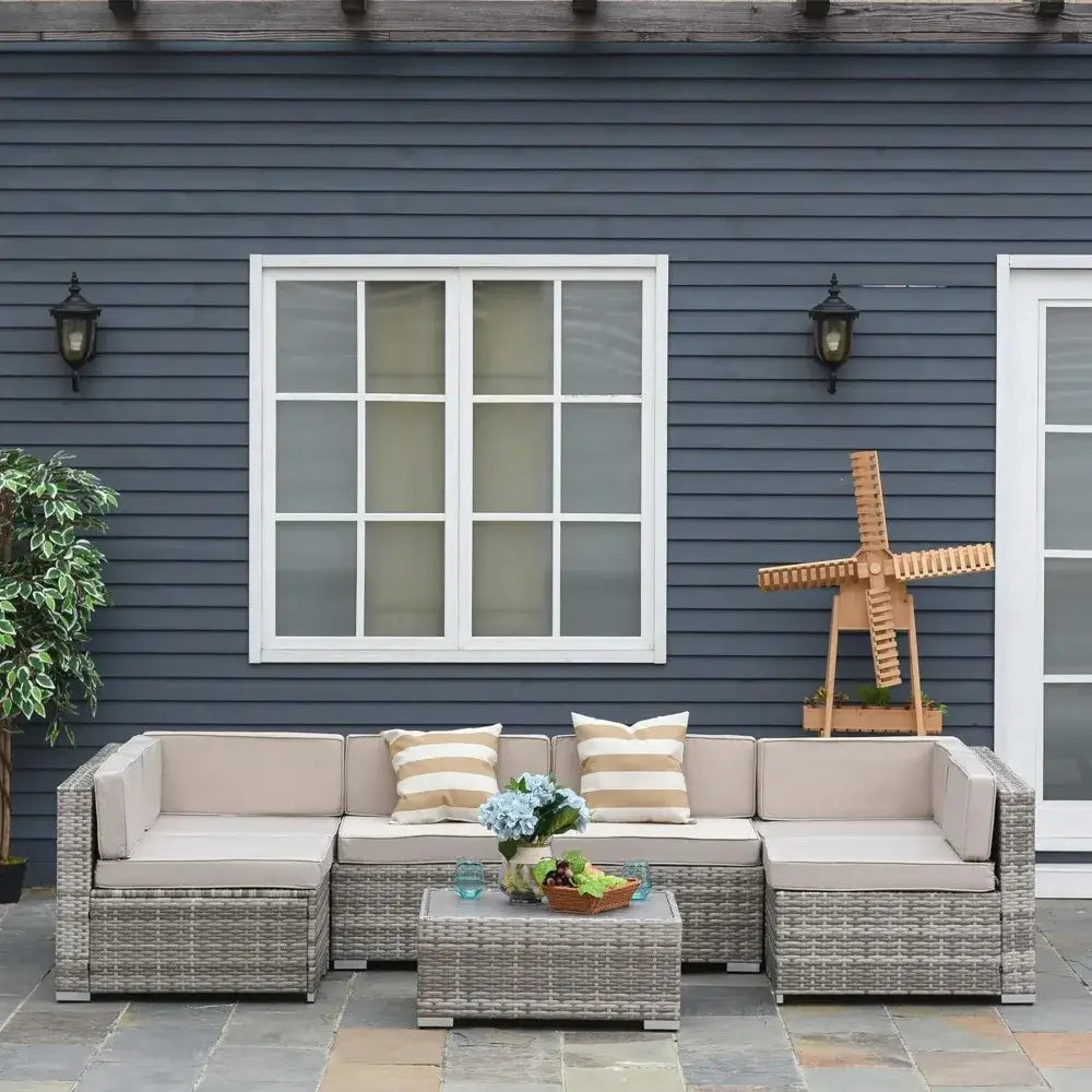 Outdoor patio set with cushions in front of a blue house.