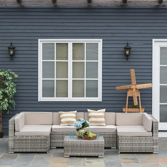 Outdoor patio set with cushions in front of a blue house.