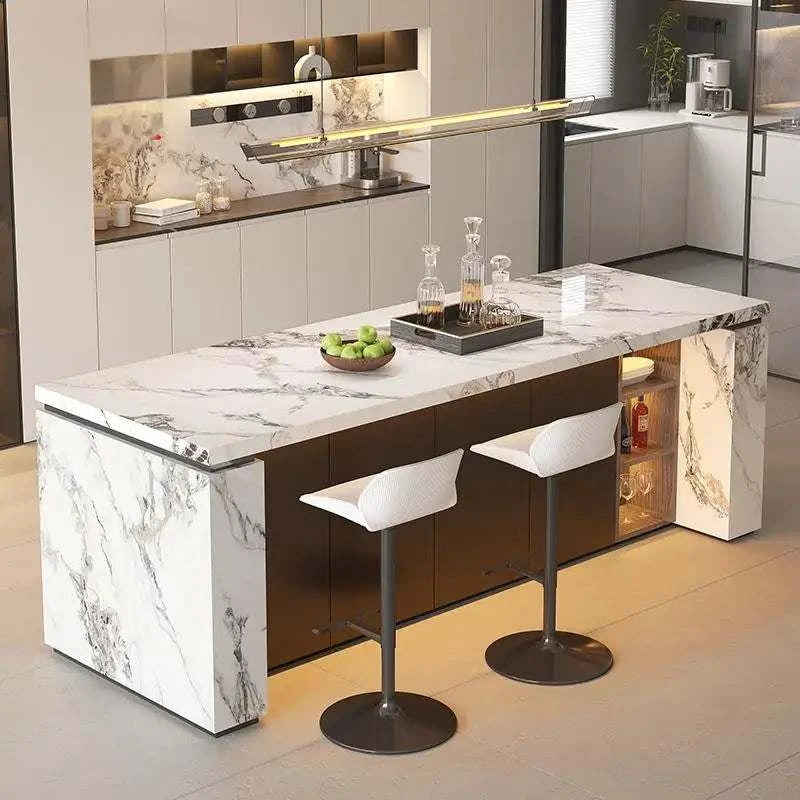 Modern kitchen island with marble countertop and bar stools in a well-lit kitchen.