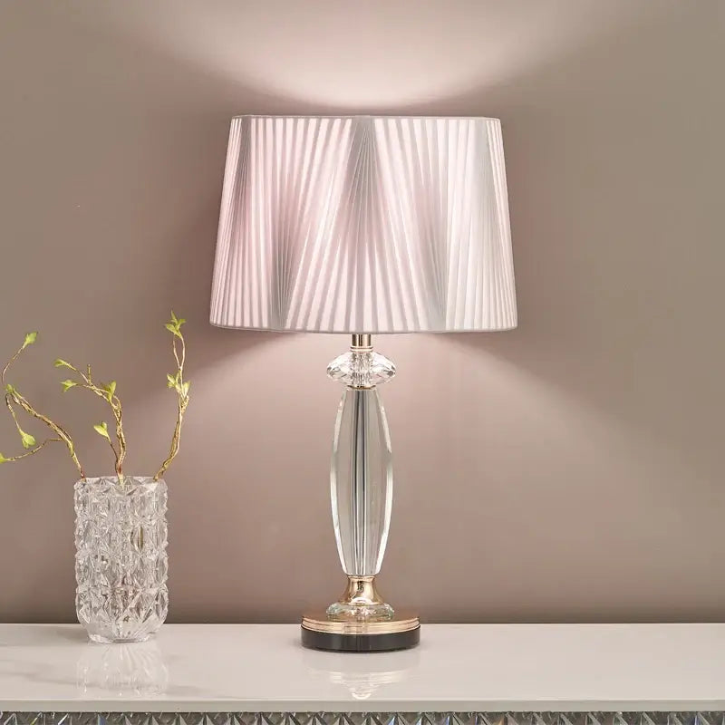 High-end crystal table lamp with fabric shade illuminating a stylish living space.