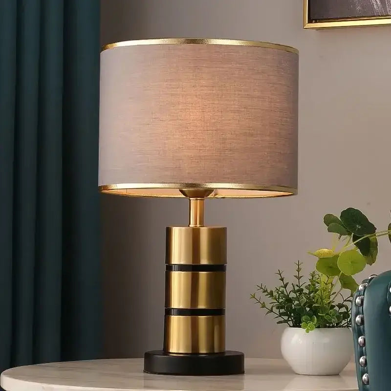 Luxury LED bedside lamp with a gold frame and fabric shade on a modern desk.