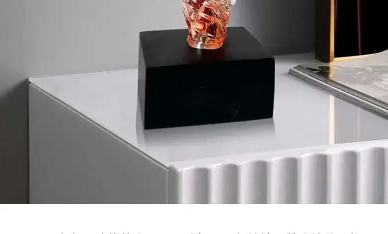 Black rectangular object on a white surface with a gray background