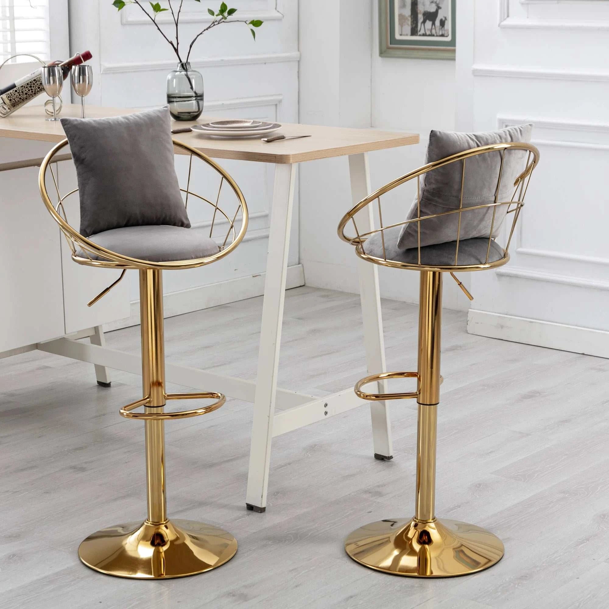 Two gold bar stools with gray cushions in a dining area.