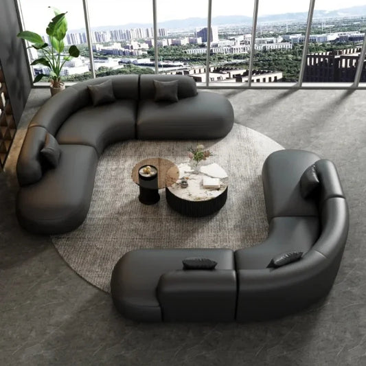 Modern black curved sofa in a room with large windows and cityscape view