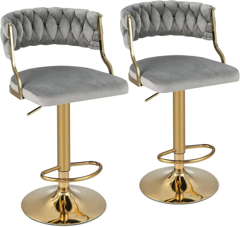 Two gray tufted bar stools with gold legs on a white background