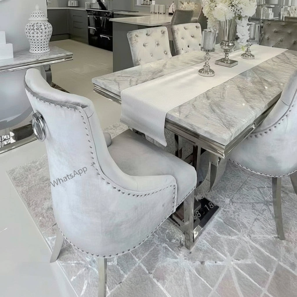 Luxury marble dining table set featuring a designer silver frame and elegant chairs in an upscale dining room.