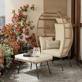 Wicker chair with cushions and a cat on a balcony with flowers