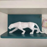 Abstract geometric panther sculpture displayed on a stylish shelf with a modern blue background.