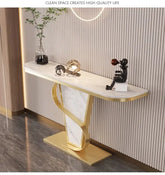 Modern console table with marble top and gold base against a striped wall.
