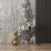 Decorative elements including a gold sculpture, black lamp, and marble-patterned wall.