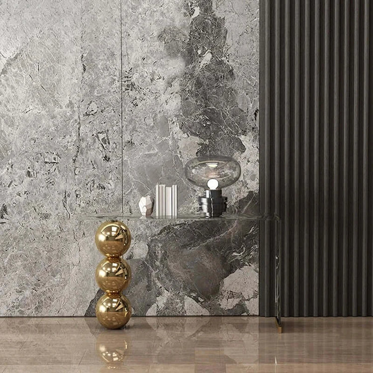 Decorative elements including a gold sculpture, black lamp, and marble-patterned wall.