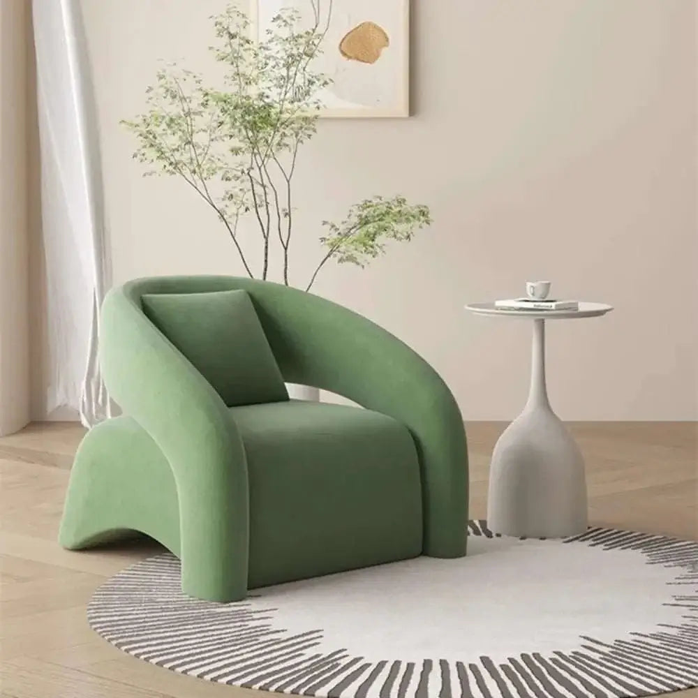 Modern green armchair in a room with a side table and plant