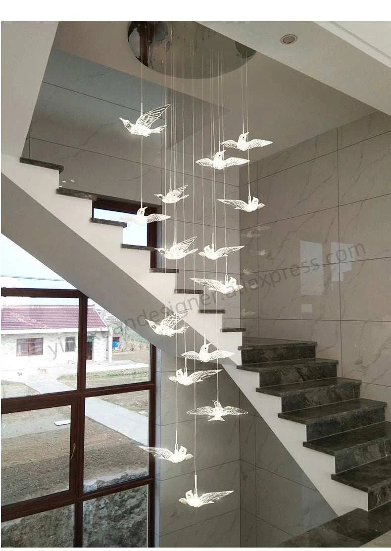 Modern chandelier hanging in a staircase with glass panels