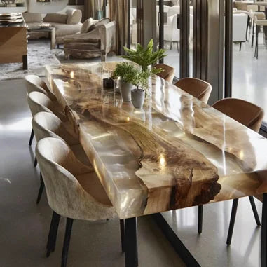 A large rectangular live-edge wood dining table with a glossy resin top showing natural wood grain, surrounded by upholstered dining chairs in a modern dining room setting.