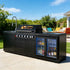 Stainless steel outdoor kitchen on wheels featuring grill, sink, and fridge, perfect for backyard cooking.