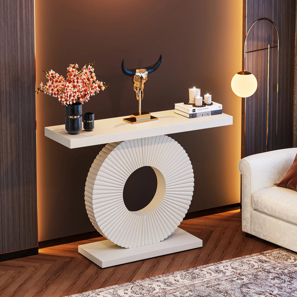 Decorative console table with floral arrangement, sculpture, and books in a stylish room.