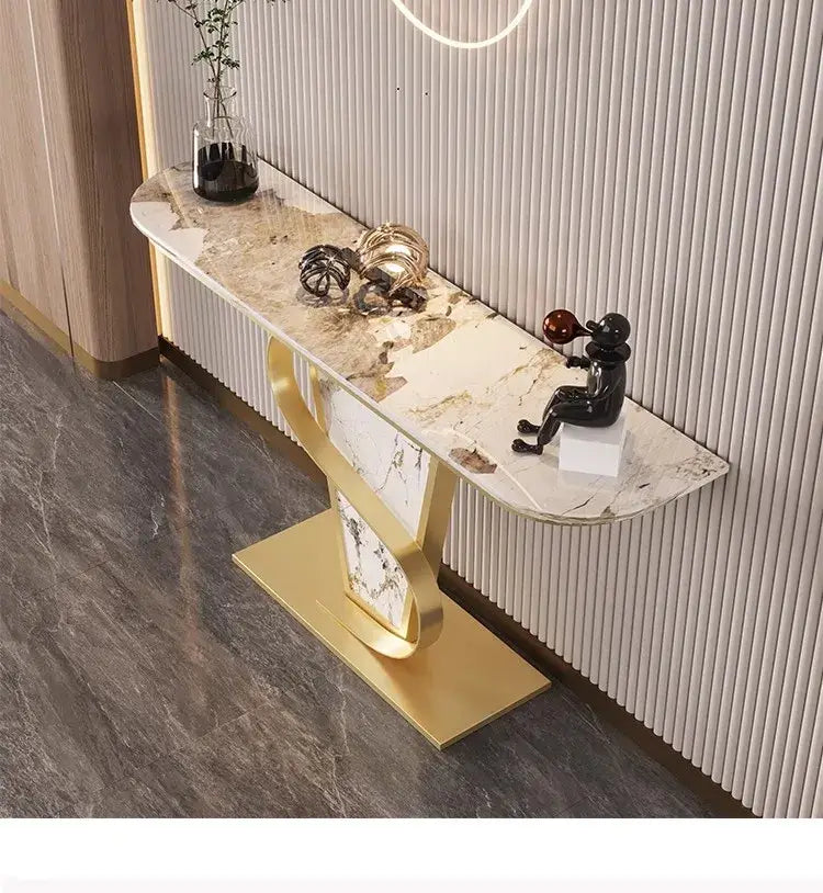 Decorative console table with marble top and gold base against a neutral wall.