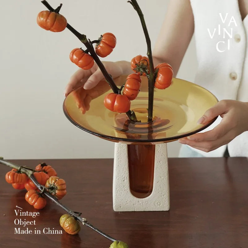 Vintage luxury glass vase showcasing orange floral accents on a stylish table.